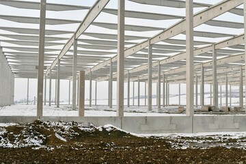 A dismantled factory hall in winter. Construction site during winter. The concept of the end of the building season and the completion of construction work before winter