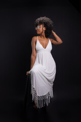 Fototapeta premium Beautiful woman, with black power hair, wearing glasses, standing wearing white clothes posing for a photo.