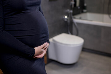 Incontinence and frequent urination during pregnancy. Pregnant woman need to pee standing by toilet...