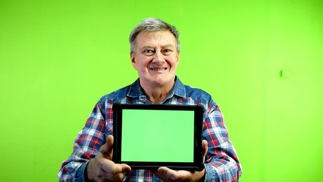 Senior man showing tablet with green screen.