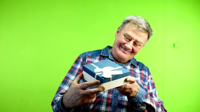 Senior caucasian man looks at gift and throws it.