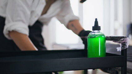 Woman hands putting tattoo equipment at studio closeup. Master organizing table