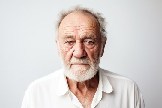 Portrait of an old man with grey hair and beard looking at camera