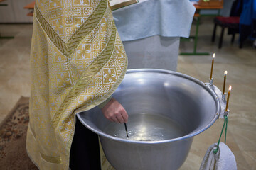 Newborn baby baptism in Holy water. baby holding mother's hands. Infant bathe in water. Baptism in...