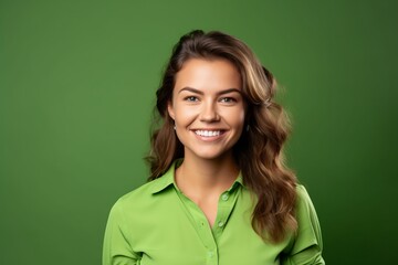 Portrait of happy smiling young businesswoman in green shirt, over green background