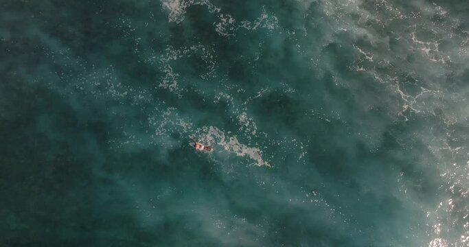 Surfer in rough ocean foam top down