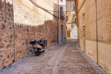 Motor bike parked on an old narrow street of historic Toledo, Spain