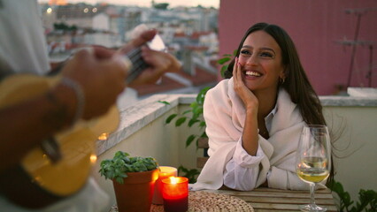 Positive woman listening music sunset place closeup. Unknown man playing ukulele
