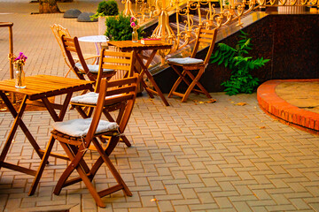 Empty table in outdoor cafe or restaurant. Tables and chairs at sidewalk cafe. Touristic setting,...