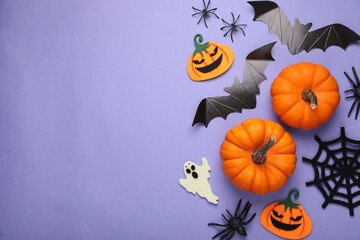 Flat lay composition with bats, pumpkins, ghost and spiders on purple background, space for text. Halloween celebration