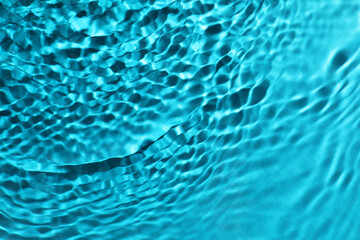 Rippled surface of clear water on light blue background, top view