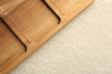 Wooden serving board on beige table, top view. Space for text
