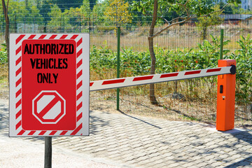 Sign with text Authorized Vehicles Only near boom barrier outdoors