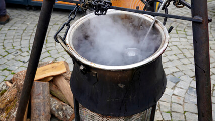 Mulled wine  is cooking in the cauldron in a Christmas market