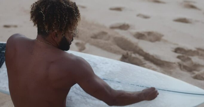 surfer using wax or waxing surfboard