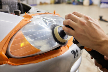 Big headlight cleaning on the car with power buffer machine at service station ,Before and after...
