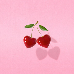 Modern retro composition made of hearts like cherries on a pastel pink background.Pop art...