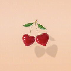 Modern retro composition made of hearts like cherries on a pastel yellow background.Pop art aesthetic, Minimal concept of Valentine's Day or love.Contemporary style.Love banner with space for text