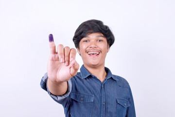 Happy Asian man showing finger with blue ink after voting on Indonesia presidential election 