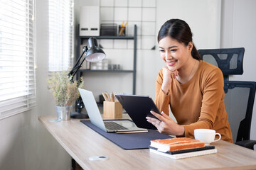 Smiling beautiful young asian woman working on laptop, business financial concept.