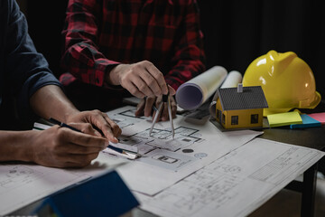 Construction engineers work on blueprints to build large commercial buildings with engineering...
