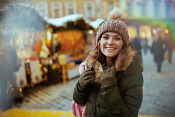 smiling modern woman at winter fair in city - obrazy, fototapety, plakaty