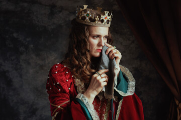 sad medieval queen in red dress with handkerchief crying - obrazy, fototapety, plakaty