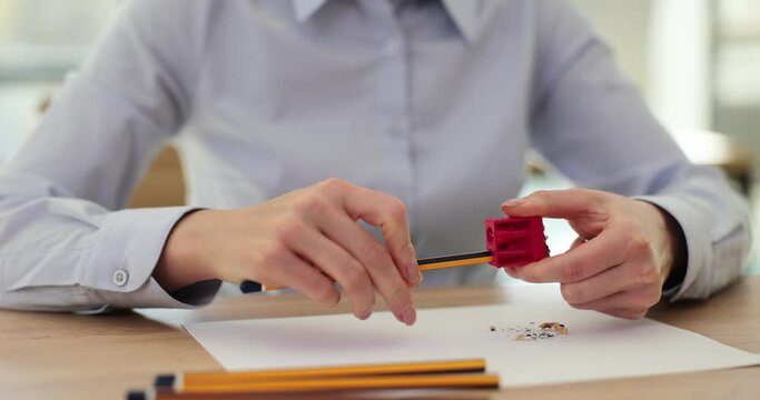 Female hands sharpening a pencil 