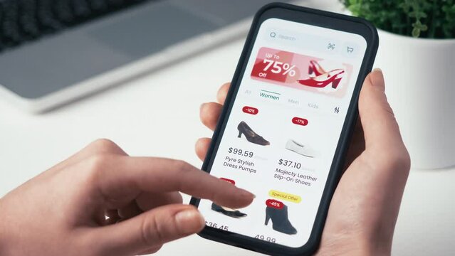 Shopping online for Christmas using smartphone retail app. Holiday sale with great discounts and special offers. Scrolling through a catalog of shoes. Fictional interface.