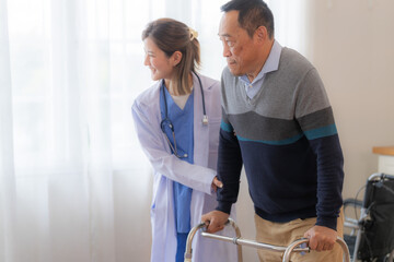Asian young nurse support senior older man walk with walker. Beautiful nurse help and take care. elderly mature grandpa patient doing physical therapy with a group of senior friends in hospital.