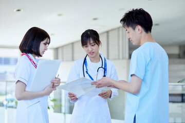 病院内にて打合わせを行う医師と看護師