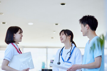 病院内にて打合わせを行う医師と看護師