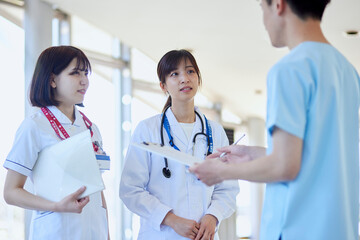 病院内にて打合わせを行う医師と看護師
