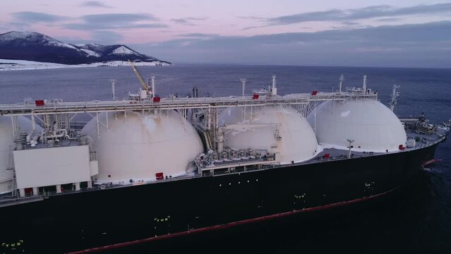Aerial of Liquified Natural Gas LNG carrier moored to a small gas terminal. Fuel crisis. 