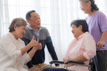 Asian young nurse support couple senior older woman in a wheelchair. elderly mature and a group of...