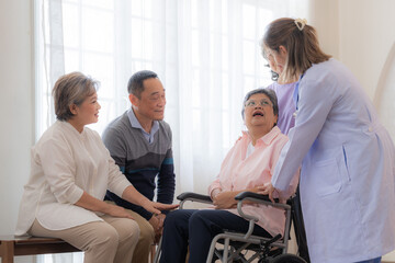 Asian young nurse support couple senior older woman in a wheelchair. elderly mature and a group of senior friends living in the hospital. socializing of retired people.