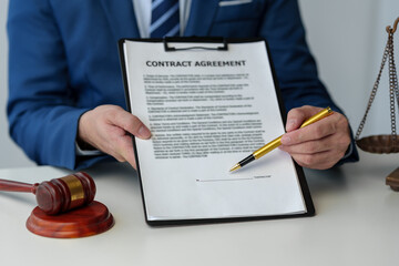 A lawyer, businessman is reviewing a business contract or life insurance contract for future...