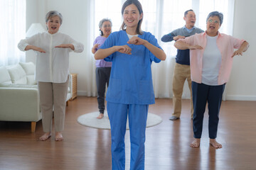 Portrait of elderly smiling Asian woman and people aerobics in nursery house. Seniors are moving...