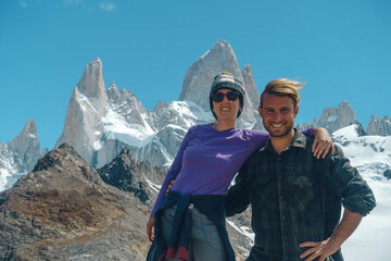 young couple take photo of them self with the FitzRoy chalten mountain at the back