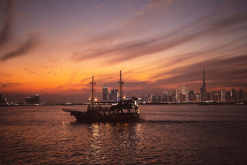 Fototapeta na wymiar Amazing shot of boat and showing dubai sky line at back side sun set time