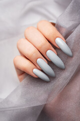 Grey nails on grey lace background.