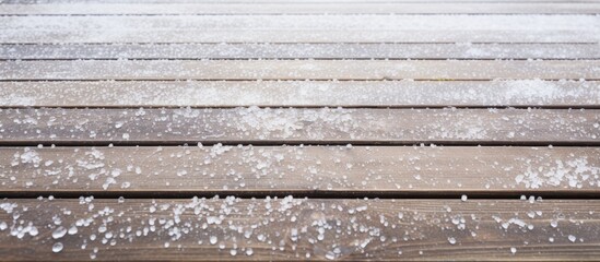 Wooden decking covered in hailstones from a hailstorm.