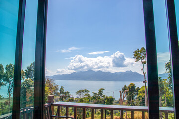 Fototapeta premium Islands, clouds floating high above the lush green treetops. beautiful landscape Take photos through rooms inside the building.