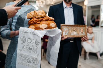 The groom's mother holds a loaf at the wedding