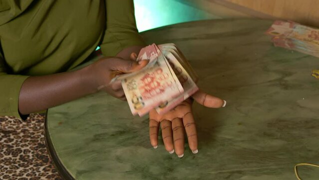 black female hands close up holding Ghanaian cedi paper money bills currency of Ghana republic in slow motion