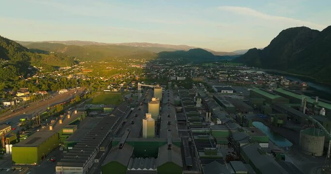 Sunrise illuminating half Norwegian industrial complex, remainder in shadow