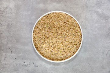 Uncooked whole-wheat or brown rice with come green grains which indicates the presence of natural chlorophyll.