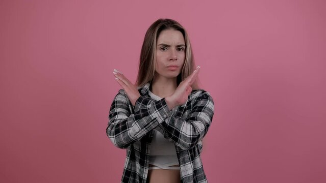 Denying, rejecting, disagree. Dissatisfied woman disapproving, making negation gesture. Portrait of young girl on pink studio background. Emotions. People. Lifestyle.