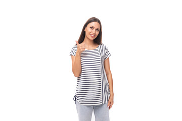 A 30-year-old brunette model woman dressed in a striped T-shirt actively gesticulates towards the...