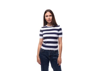 portrait of a slender young brunette caucasian woman with light make-up dressed in a striped t-shirt and jeans